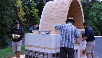 (from left) Anoka-Ramsey Community College students Wes Van’t Hull, Alex Bivans and Mike Smieja join guest artist Ted Neal to build a new wood fire kiln at the college.