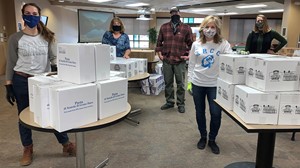staff members with food staged for packing grab and go bags 